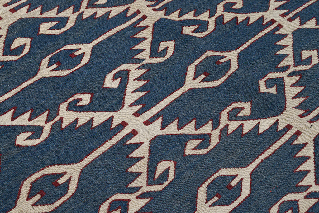 Handwoven Navajo-style Kilim rug with geometric blue, ivory, and red pattern